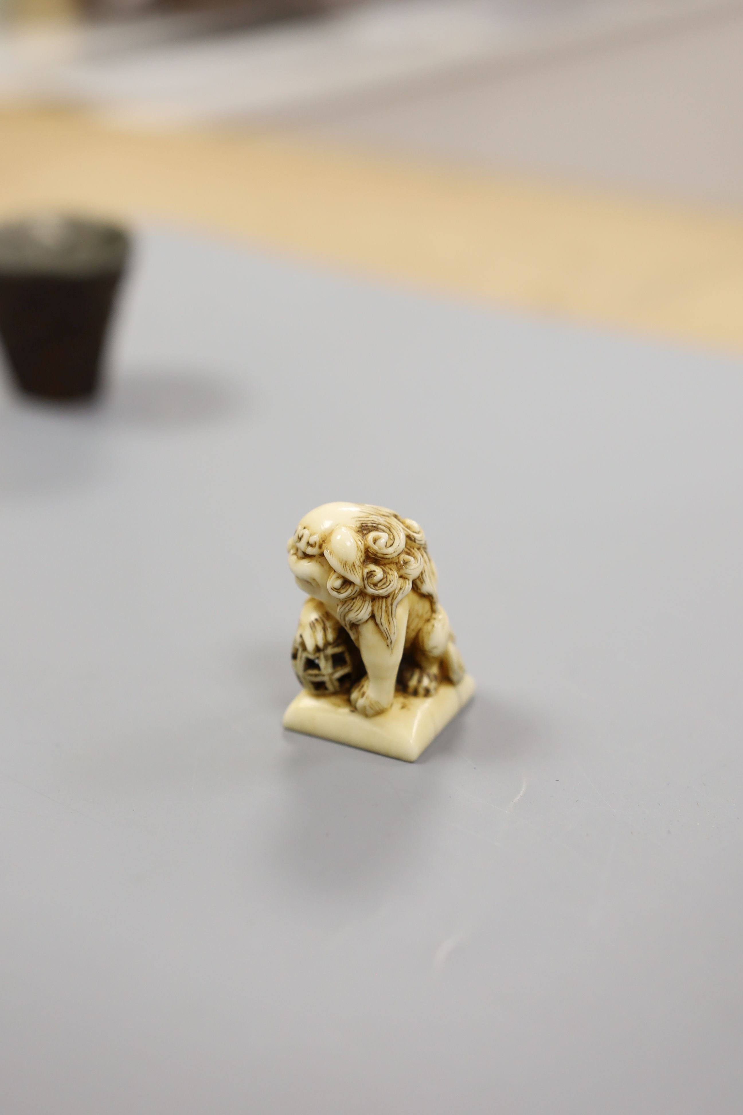 A Chinese or Japanese ivory lion dog 18th/19th century and a Chinese carved nut cup, 19th century. 4cm